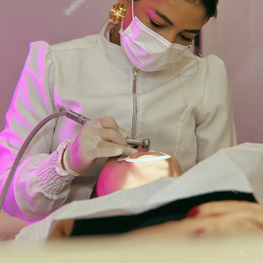 Sessão de laserterapia, com a luz do laser sobre a boca da paciente